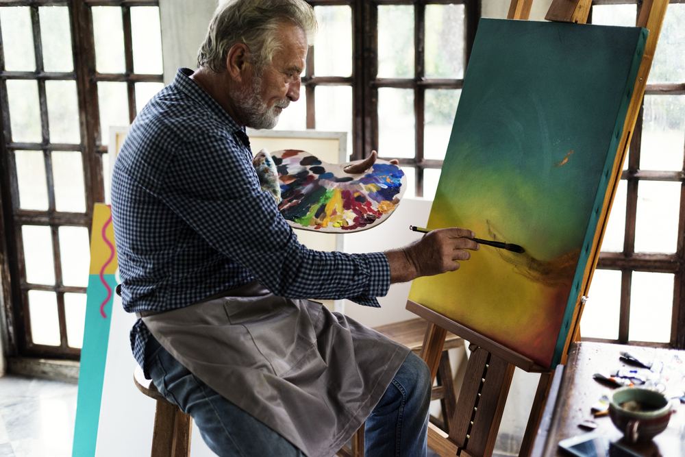 Artist painting artwork at workspace