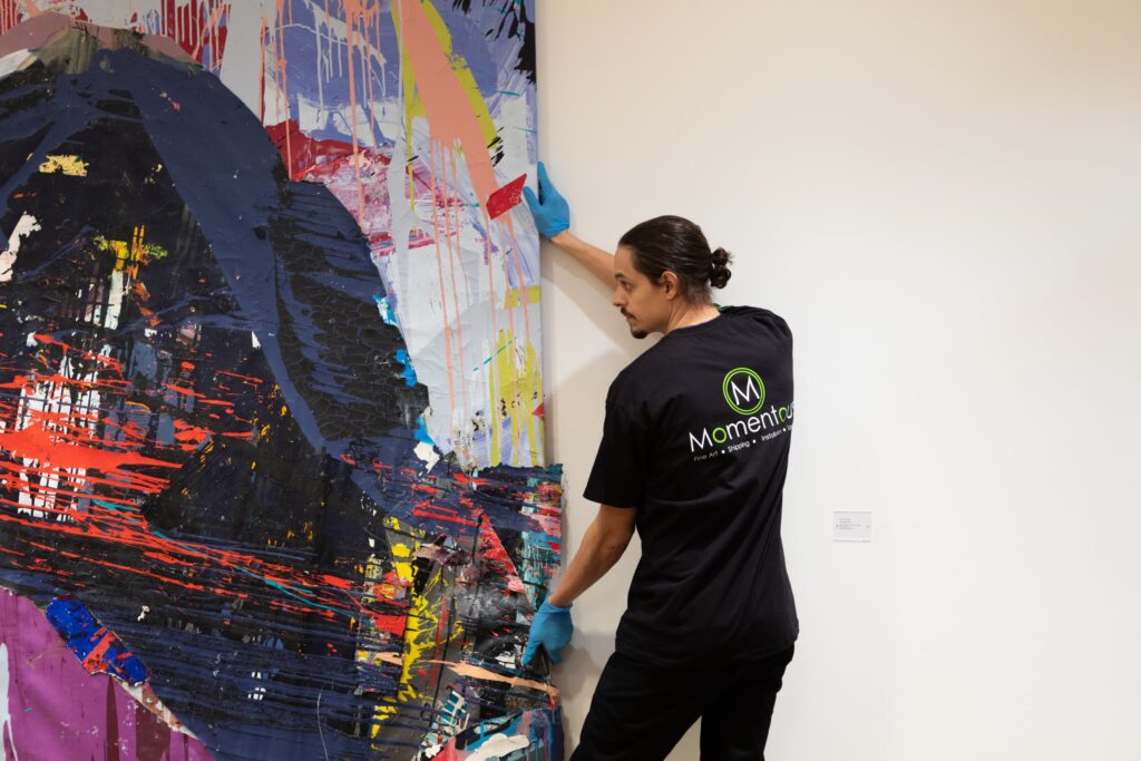 Momentous Relocation employee moving a painting.