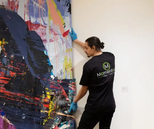 Momentous Relocation employee moving a painting.