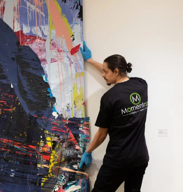 Momentous Relocation employee moving a painting.