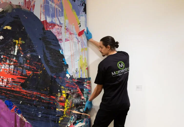 Momentous Relocation employee moving a painting.