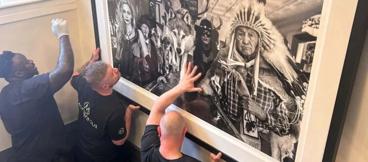 Momentous Relocation team hanging a large piece of artwork.