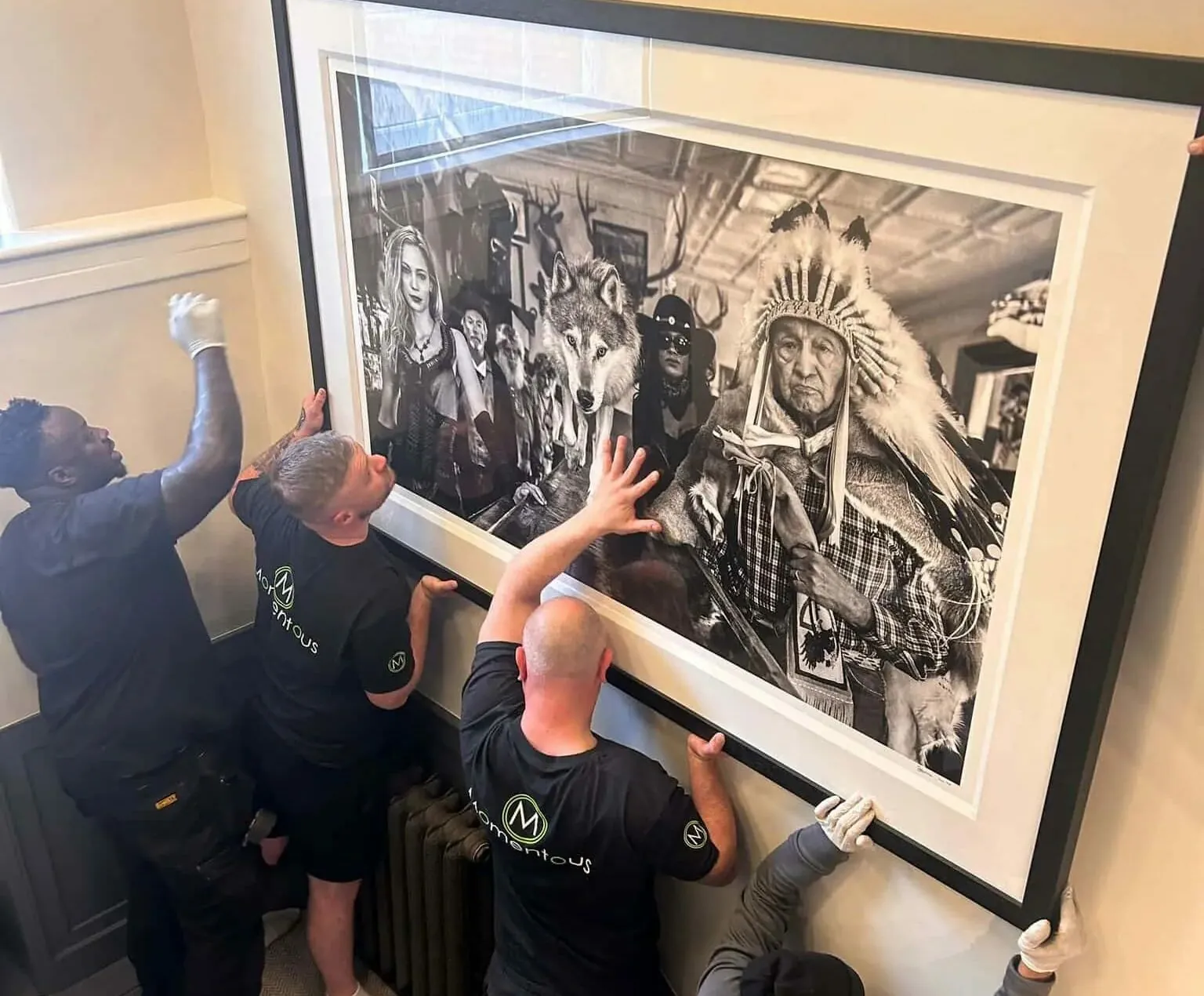 Momentous Relocation team hanging a large piece of artwork.