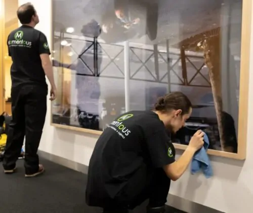 Momentous Relocation team polishing hanging artwork.