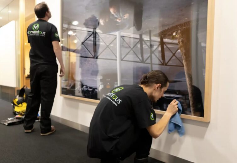 Momentous Relocation team polishing hanging artwork.