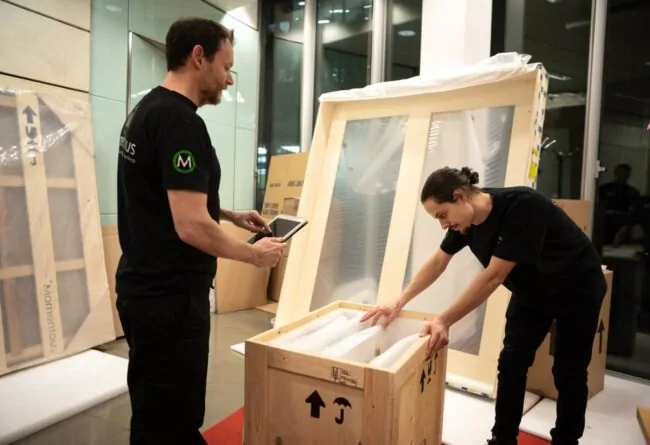 Momentous Relocation team putting items into a crate.