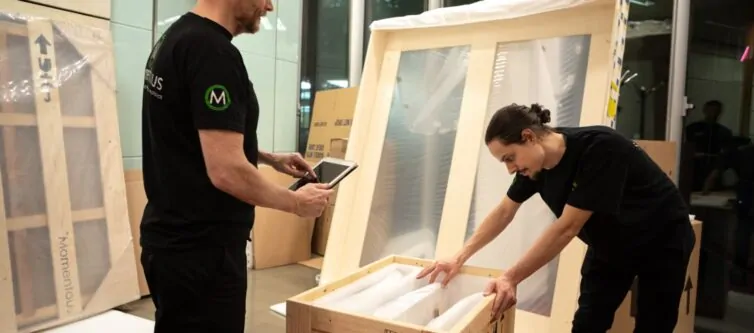 Momentous Relocation team putting items into a crate.
