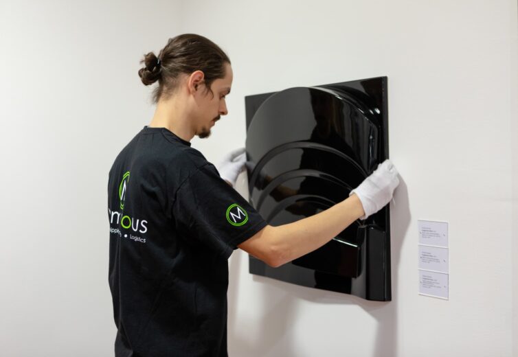 Momentous Relocation worker hanging some artwork, with white gloves.