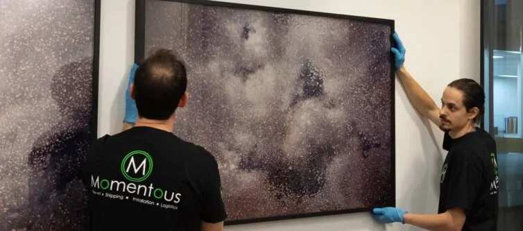 Momentous Relocation team hanging artwork.