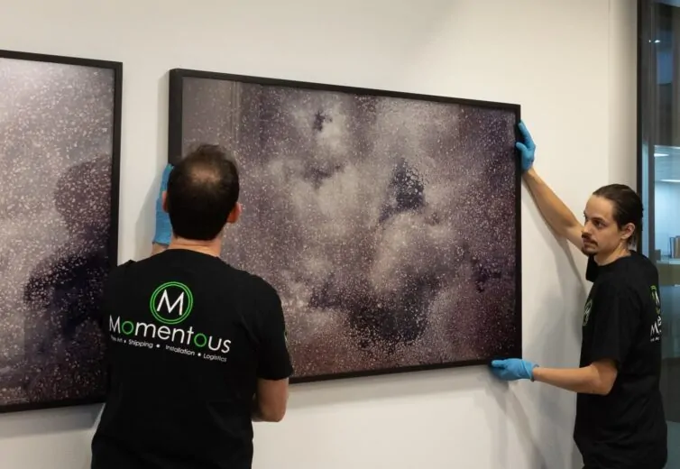 Momentous Relocation team hanging artwork.